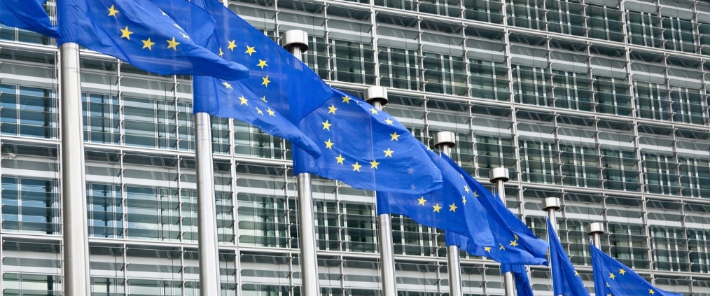 flagi unii europejskiej przed gmachem parlementu europejskiego